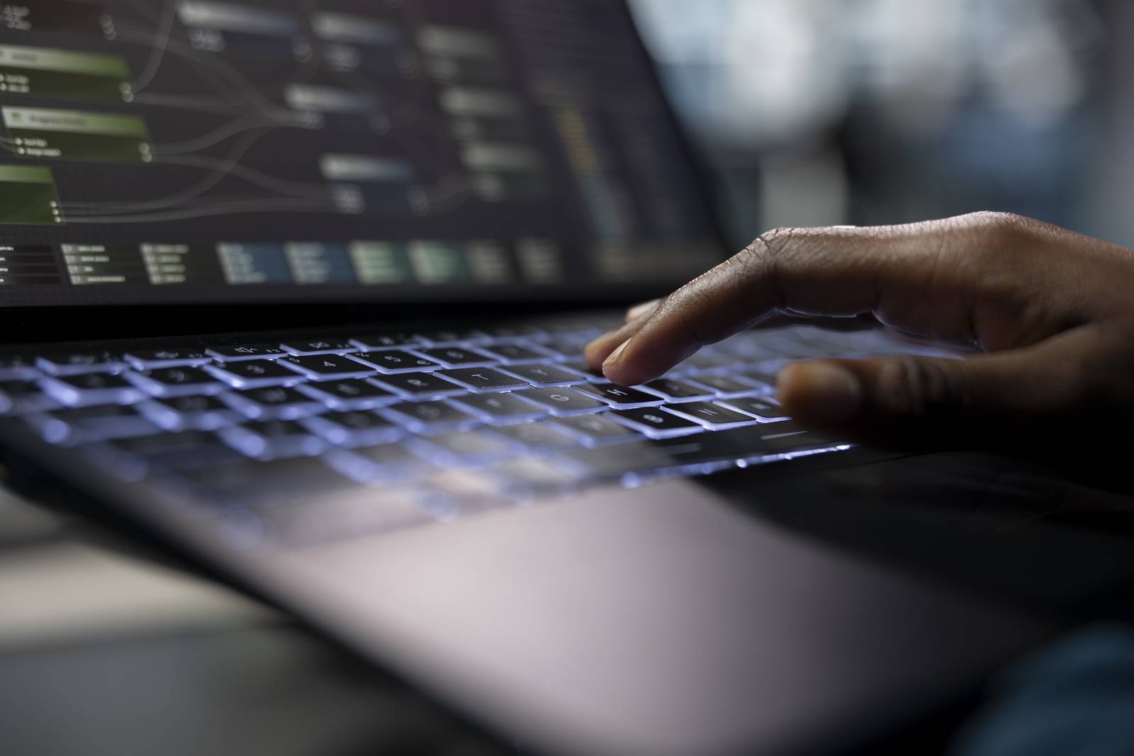 Server room programmer coding on laptop, typing on keyboard